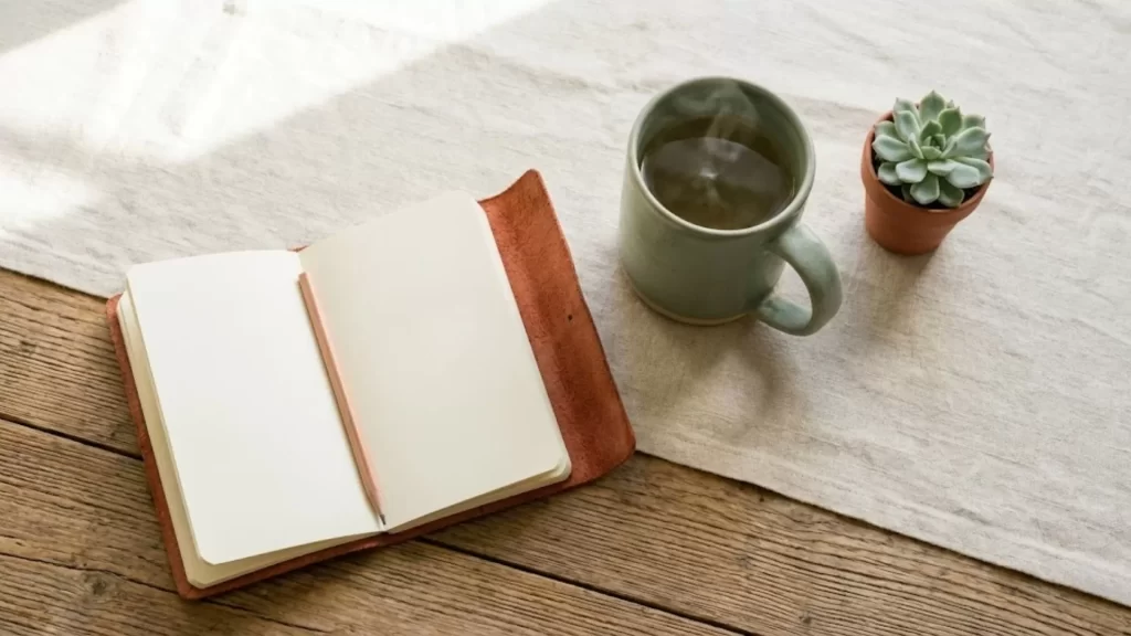 configuração de ritual matinal de mindfulness com diário, chá e planta — prática de controle da ansiedade